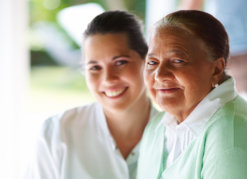 an elderly woman and a caregiver showing smiling faces